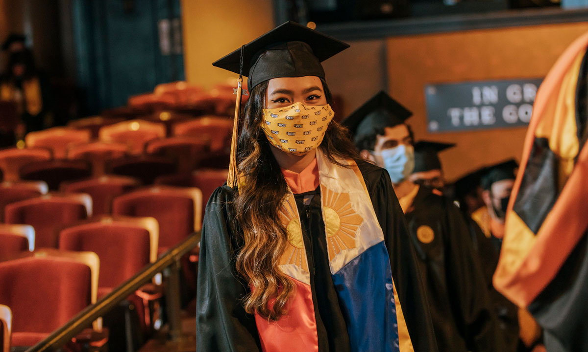 Female student walking at commencement in 2021