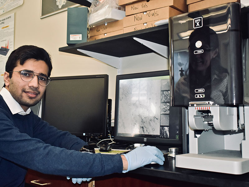 NanoNuclear Engineering Lab Member using a Microscope