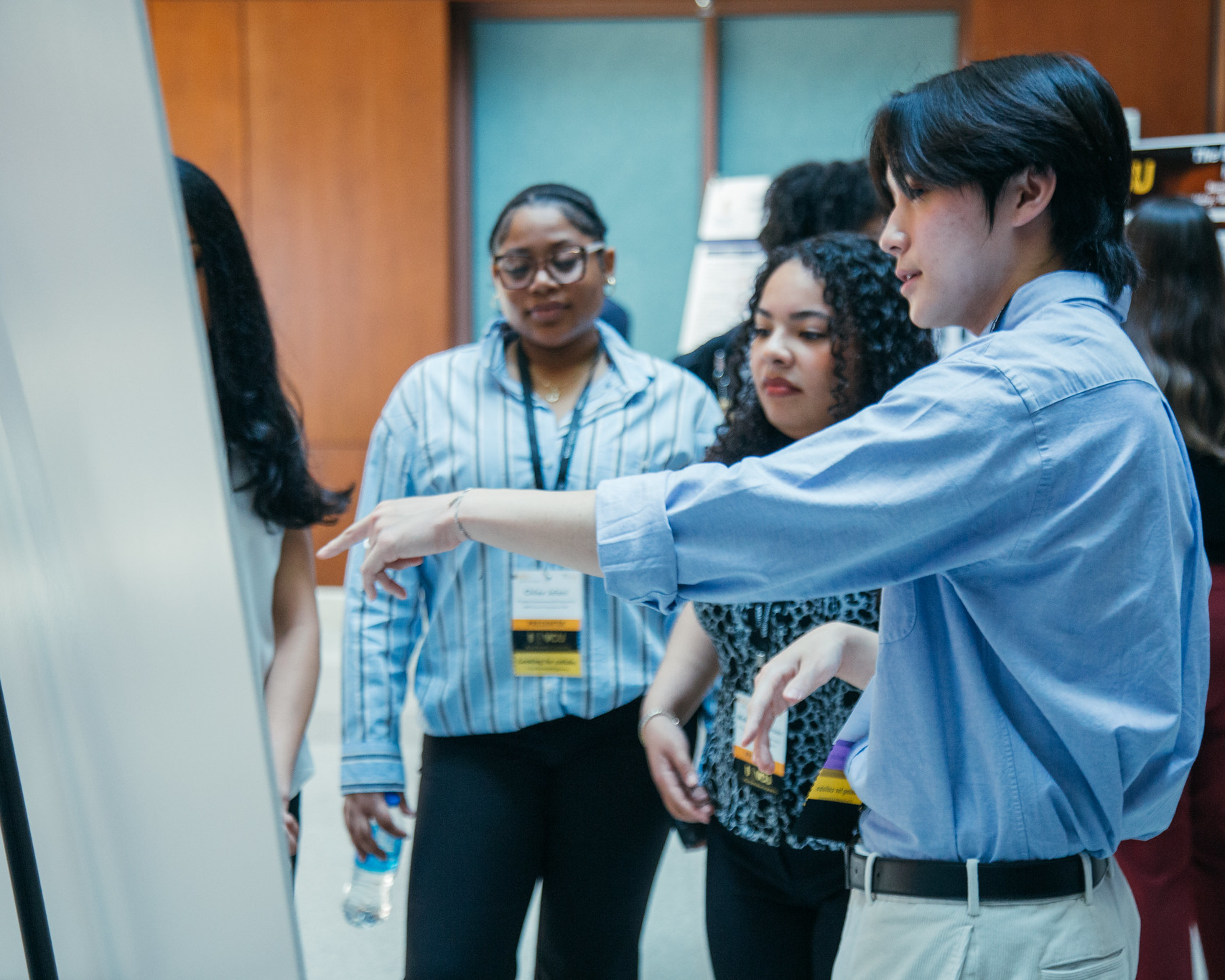Student presenting their poster at a research symposium