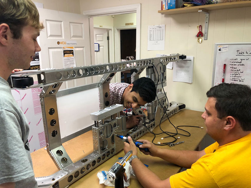 Brendan Fisher, Vineet Polam and Tyler Brayton assembling the pod vehicle’s frame inside the team’s workspace at Build, RVA.