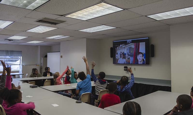 Distance Learning Lab at John B. Cary Elementary School in Richmond, Virginia. Seen on the large screen are Kiara Corbin, a junior majoring in mechanical engineering, and Adam Hamel, a lab technician, who are at VCU Engineering's Maker Garage.