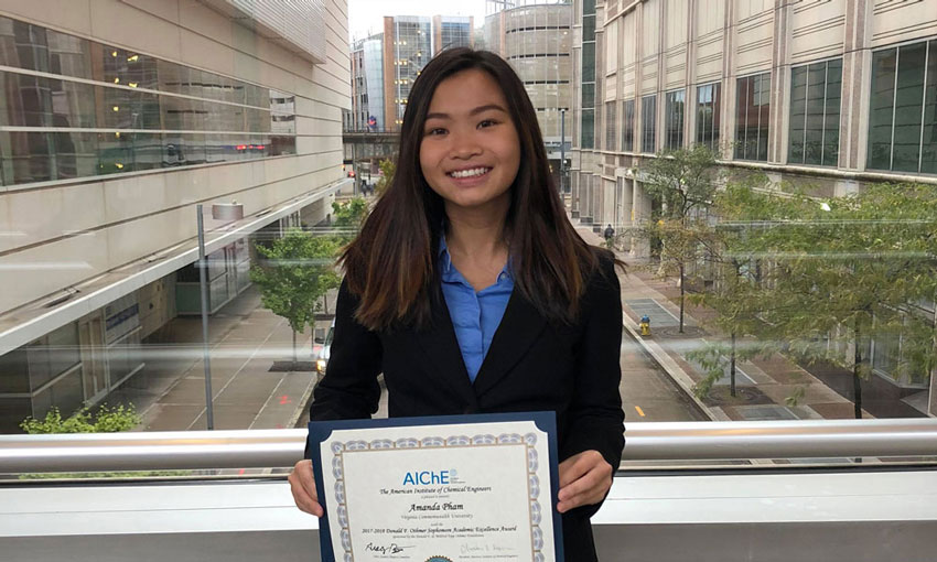 Portrait of Amanda Pham holding her AiChe award certificate.