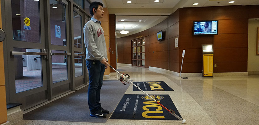 A student using the RoboCane device which helps those with visual impairments